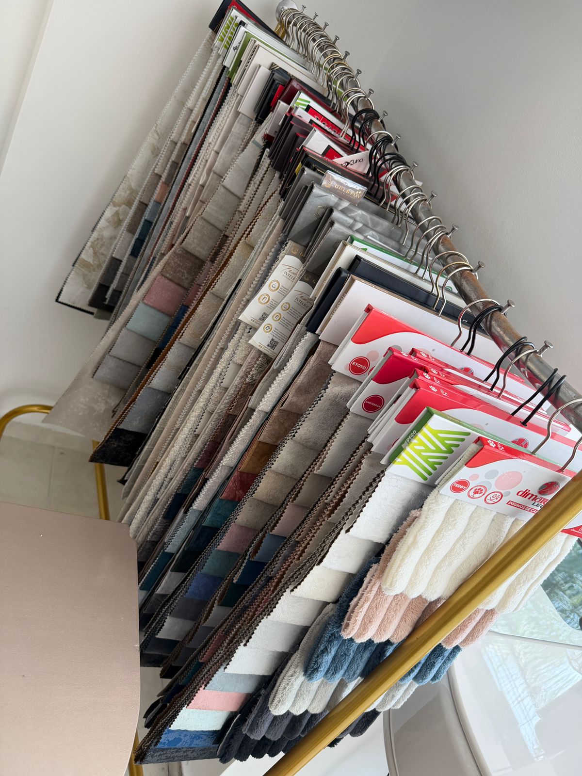 Exhibición completa del estand de colores y telas disponibles en Atenea's Luxury Dosquebradas — todos los tapizados premium